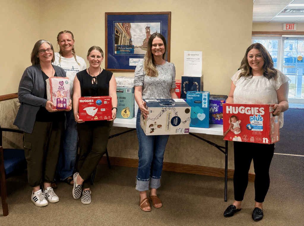 Group of women holding boxes of diapers